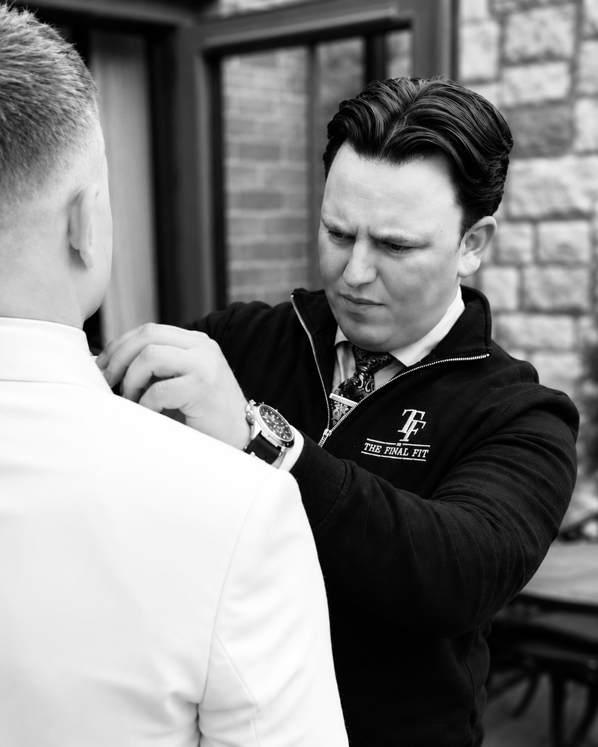 Raymond adjusting a groom’s bow tie on the morning of the wedding.